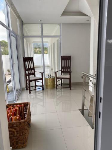 a living room with two chairs and a basket on the floor at Bed and Breakfast Villa Livadia in Cape Town