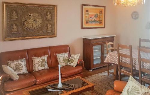 a living room with a brown leather couch and a table at 2 Bedroom Nice Home In Plonevez Porzay in Plonévez-Porzay