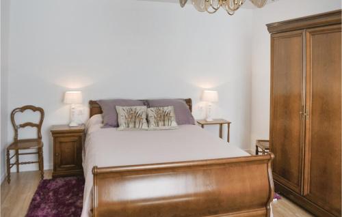 une chambre avec un lit et une armoire en bois dans l'établissement 2 Bedroom Nice Home In Plonevez Porzay, à Plonévez-Porzay