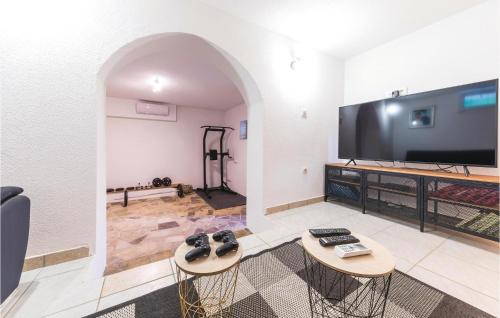 a living room with two tables and a large screen tv at Two-Bedroom Holiday Home In Trilj in Trilj