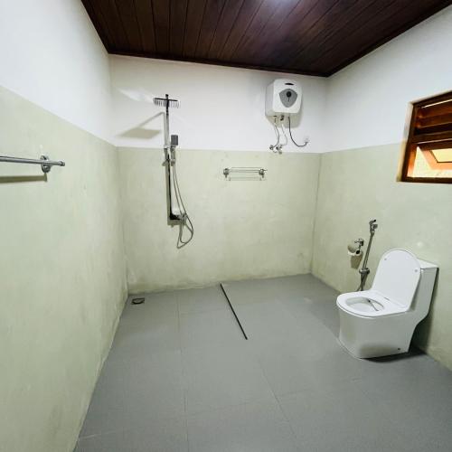 a bathroom with a toilet and a shower at Hanguk Lanka Lagoon Villa in Tangalle