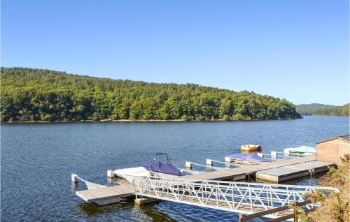 a dock with two boats on a lake at Awesome Home In Canihuel in Canihuel