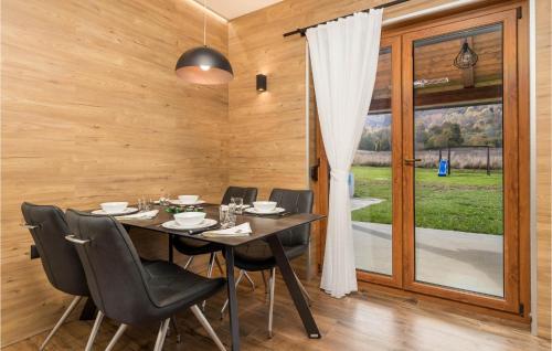 a wooden dining room with a table and chairs at Lovely Home In Tuk Vojni in Tuk Vojni