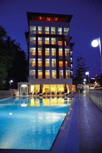 a hotel with a swimming pool in front of a building at Sırma Hotel - All Inclusive in Side