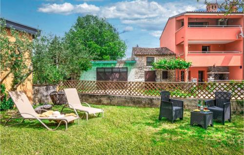 a yard with chairs and a table and a building at Beautiful Home In Krnica With Sauna in Krnica