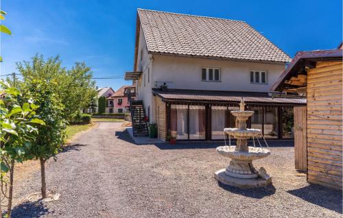 a stone fountain in front of a house at 2 Bedroom Awesome Apartment In Fuzine in Fužine