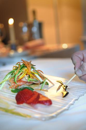 a plate of food on a table with food on chopsticks at Hotel Ad Gallias in Bard