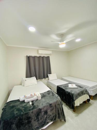 a room with two beds and a ceiling at Mar Suites Toninhas in Ubatuba