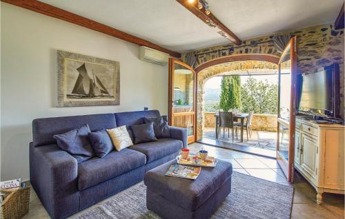 a living room with a blue couch and a tv at Casa Castelli in Garlenda