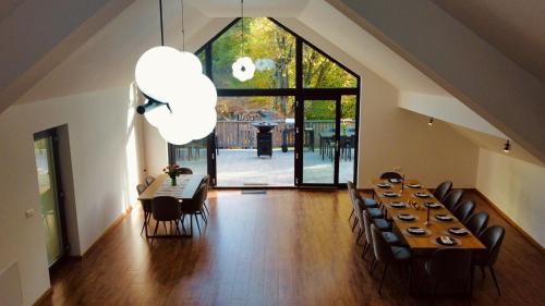 ein Esszimmer mit Tisch und Stühlen und einem großen Fenster in der Unterkunft Riverside Avrig in Avrig