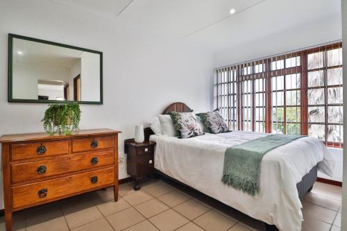 Un dormitorio con una cama, una cómoda y un espejo. en 22 A Ferrox, en Mossel Bay