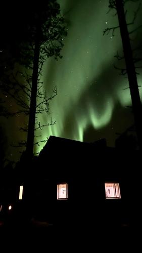 a house with two windows under a green sky at Villa Kaikuranta in Nellimö