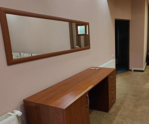 a wooden desk with a mirror on a wall at Areg Hotel in Yerevan