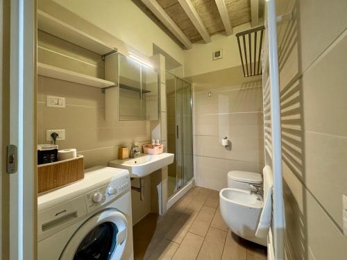 a bathroom with a washing machine and a sink at Niki O. Apartments in Parma