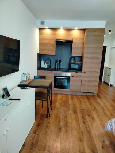 a kitchen with wooden cabinets and a wooden table at Apartament Julia in Zamość