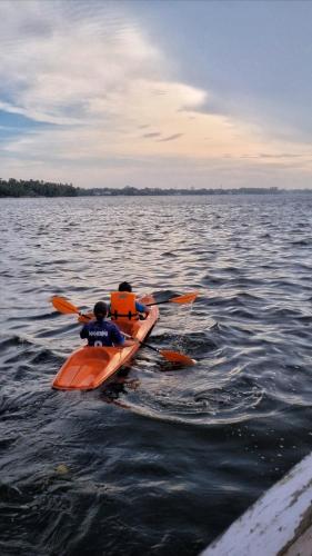 two people in kayaks on a large body of water at Traditional Kerala Home in Kollam