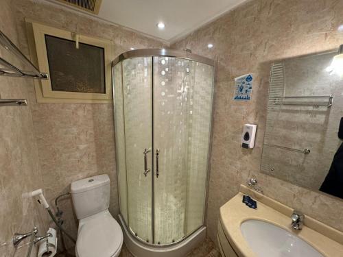 a bathroom with a shower and a toilet and a sink at غرف تاج الذهبية الملاوي in Mecca
