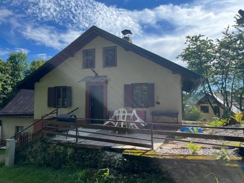 a small white house with a chair on the front porch at Chalupa pod lesem in Trutnov