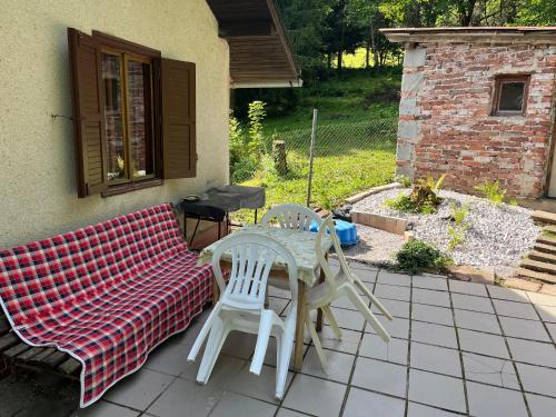 a patio with a table and chairs and a couch at Chalupa pod lesem in Trutnov