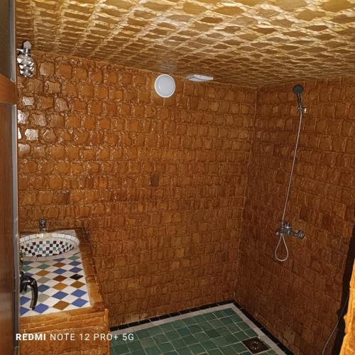 y baño con ducha en una pared de ladrillo. en Riad amal, en Fez