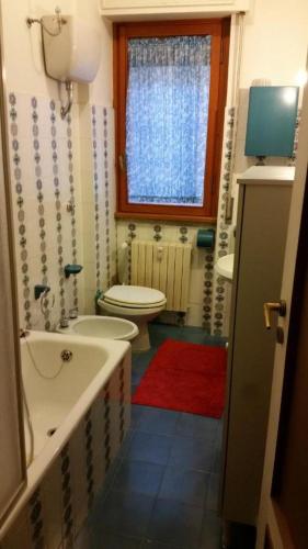 a bathroom with a sink and a toilet and a window at Casa Ena in Roccaraso