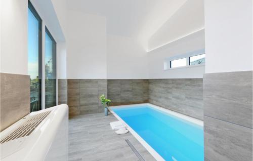 ein Swimmingpool in einem Raum mit Badewanne und Fenster in der Unterkunft Stunning Home In Lembruchdümmer See in Lembruch