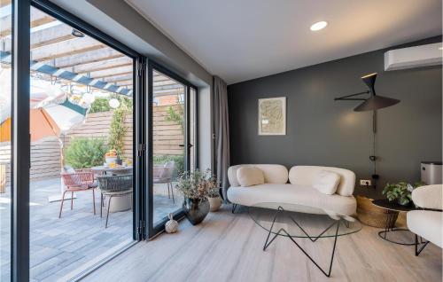 a living room with a white couch and a sliding glass door at Beautiful Home In Privlaka in Privlaka