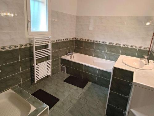 une salle de bain avec une baignoire et un lavabo dans l'établissement Spacieuse villa familiale avec terrasses à 500m du Bassin - FR-1-736-21, à Lège-Cap-Ferret