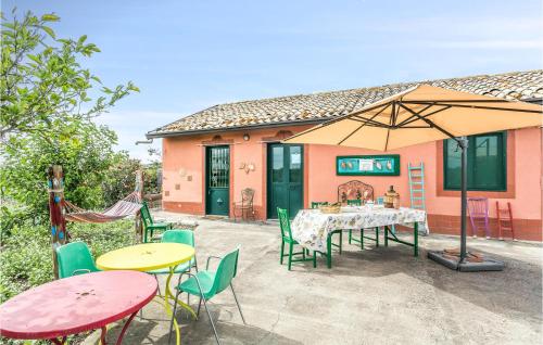 a patio with tables and chairs and an umbrella at 1 Bedroom Nice Home In Paternò in Paterno