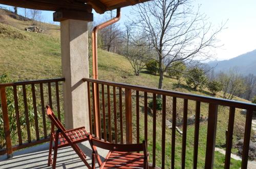a wooden chair sitting on a porch with a view at Alloggio Starteri in Sordevolo
