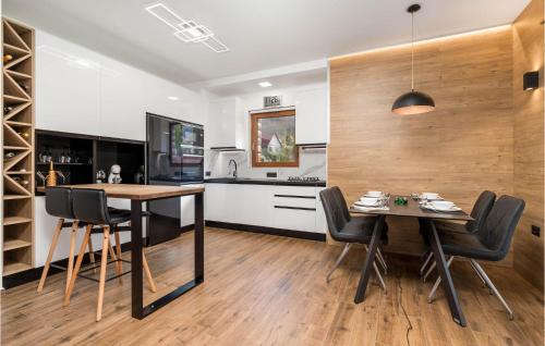 a kitchen and dining room with a table and chairs at Lovely Home In Tuk Vojni in Tuk Vojni