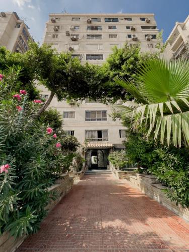 a large white building with a brick walkway at The 2BDR Obsidian Jacuzzi Stay 5min to CAI Airport in Cairo