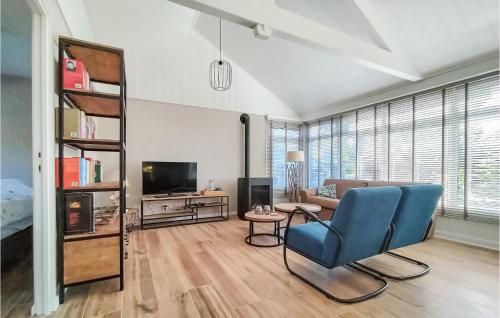 a living room with a blue chair and a tv at Zeeuwse Parel in Scherpenisse