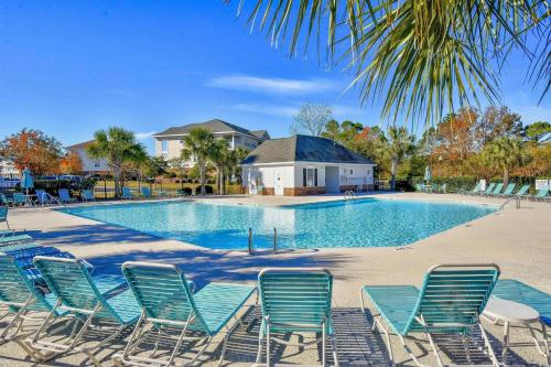 a group of chairs sitting around a swimming pool at The Norman Retreat At Barefoot Resort! 3 Bedroom in Myrtle Beach