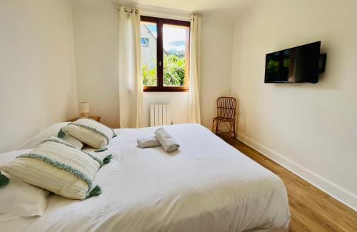 a bedroom with a large white bed with two pillows at L'Orée du Golf - Maison Deauville 8 personnes in Saint-Arnoult