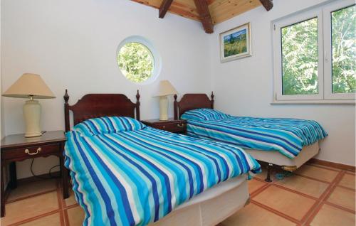 a bedroom with two beds and a desk and two windows at Pet Friendly Home In Cara in Čara