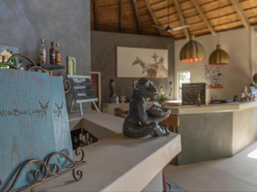 a statue of a dog sitting on a counter in a restaurant at The Wild Blue Lodge SAFARI & SPA in Hoedspruit