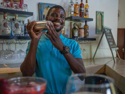 a man is smiling while holding a bar at The Wild Blue Lodge SAFARI & SPA in Hoedspruit