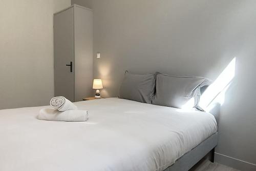 - un lit blanc avec une serviette blanche dans l'établissement Suite Beaulieu 5 - Charmant Appartement Moderne 2 ch- vue Cathédrale, à Angoulême