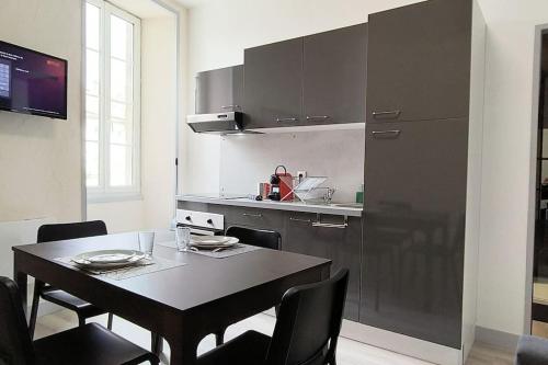 une cuisine avec une table et des chaises et une cuisine avec un comptoir dans l'établissement Suite Beaulieu 5 - Charmant Appartement Moderne 2 ch- vue Cathédrale, à Angoulême