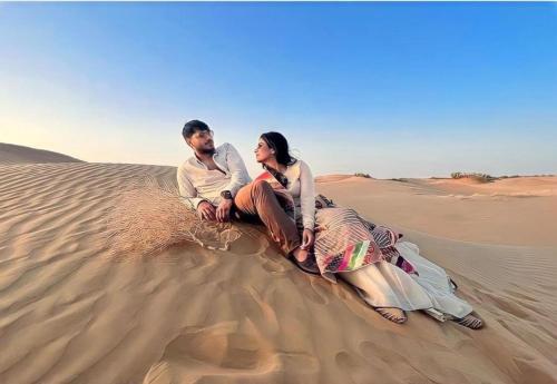 a man and woman sitting on a camel in the desert at Excellent Desert Safari camp in Sām