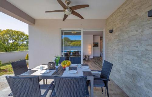 une table à manger avec des chaises et un ventilateur de plafond. dans l'établissement 3 Bedroom Nice Home In Kapovci, à Brusići