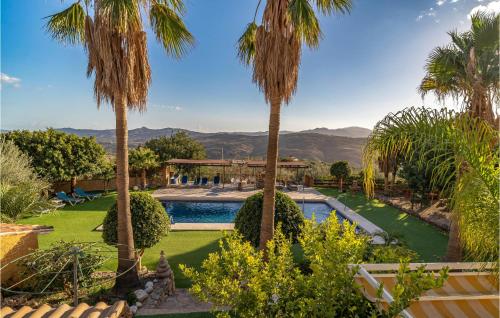 einen Garten mit Palmen und einem Pool in der Unterkunft Holiday Home Periana - 03 in Periana