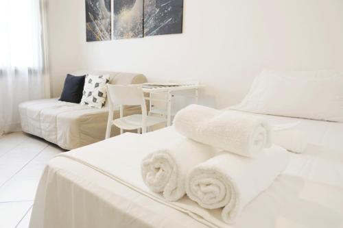 una stanza bianca con due letti e un tavolo di MICHELANGELO 26 Monolocale a Milano