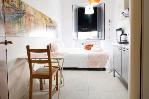 ミラノにあるSmart Apartment Central Stationの小さなベッドルーム(ベッド1台、テーブル、椅子付)