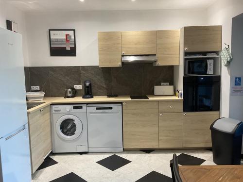 a kitchen with a washing machine and a washer at Domaine Le Rocher d Argent avec Piscine Extérieur ,Jacuzzi Intérieur et Salle de jeux in Berre-les Alpes