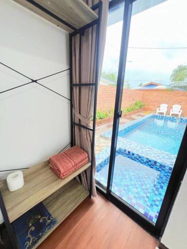 a room with a view of a swimming pool through a window at Private Pool Villa Safiya in Pulau Langkawi