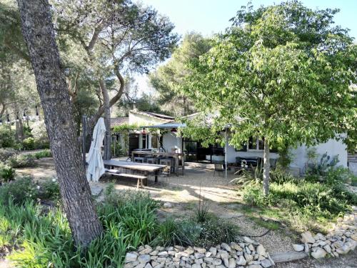 une arrière-cour avec une table de pique-nique et des arbres dans l'établissement La Planque des Alpilles, à Fontvieille