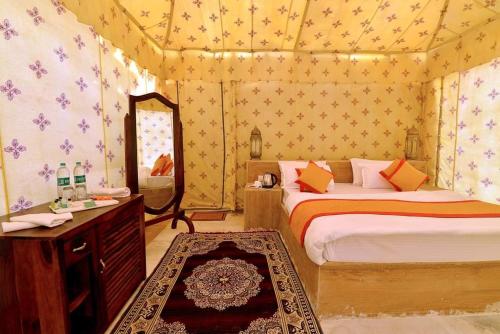 a bedroom with two beds and a vanity and a mirror at Excellent Desert Safari camp in Sām