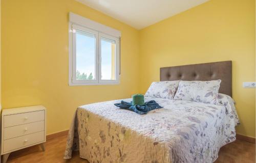 a bedroom with a bed with yellow walls and a window at Amazing Home In Candamo With Kitchen in Candamo